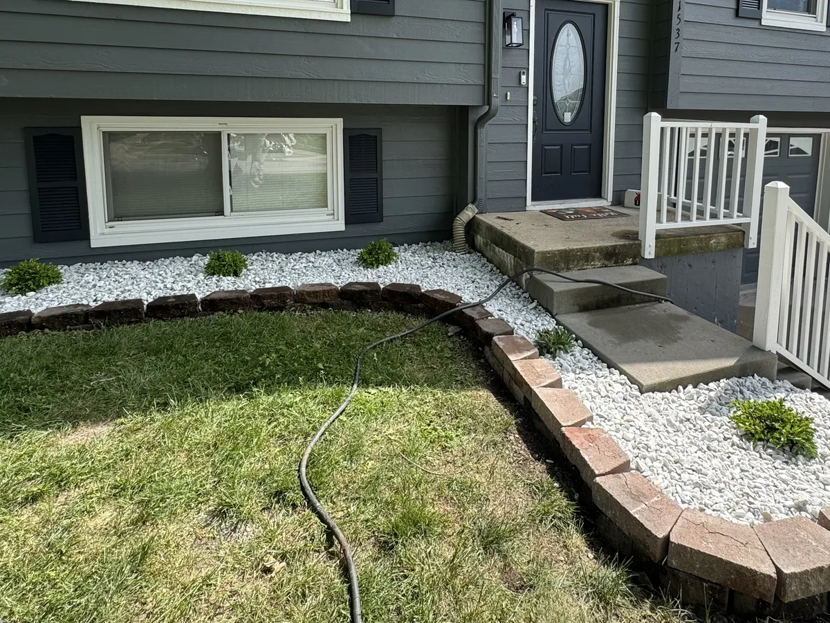 Front yard landscaping with white rock beds and stone edging installed by B&B Lawn & Landscape in the Kansas City metro area